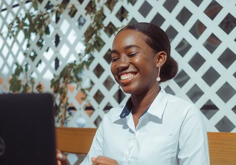 Mujer sonriendo frente a su laptop usando Megactivo
